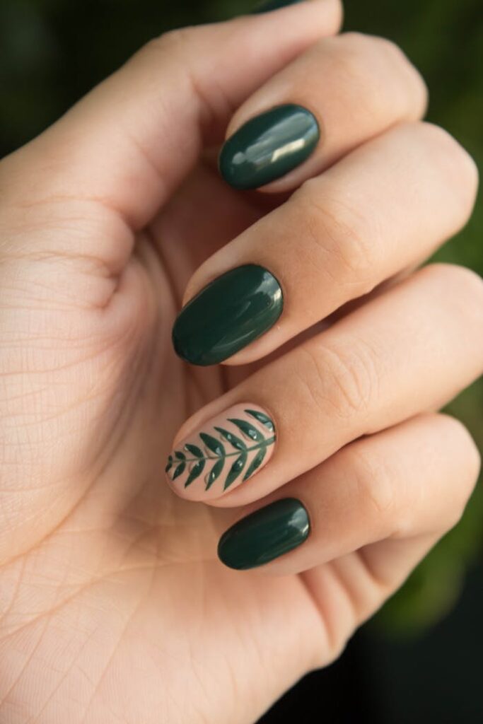 The Art of Drawing Readers In: Your attractive post title goes here Close-up of a stylish green manicure with a leaf design, showcasing glossy fingernails and natural skin tone.